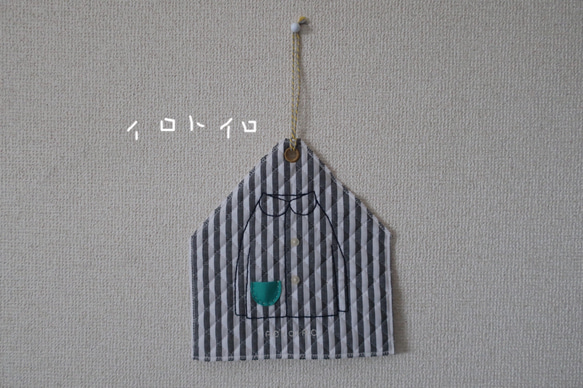 手刺繍のタペストリー（シャツにブローチ）